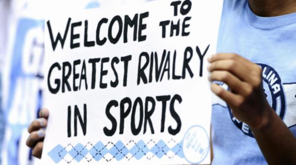 A UNC fan holds a handmade poster about the famous UNC-Duke rivalry.